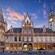 A watch tower next to a grand building built in a neo Gothic style